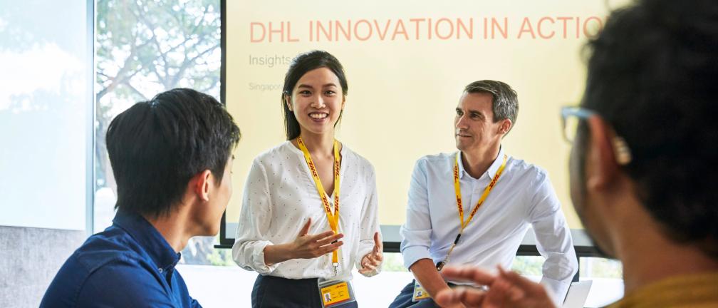 Four DHL employees in a meeting.