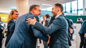 Two male colleagues network joyfully at DHL event