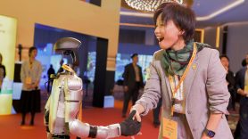 Customer Manager Tracy Liang shakes hand with robot