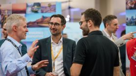 Three men have a conversation at DHL Now & Next