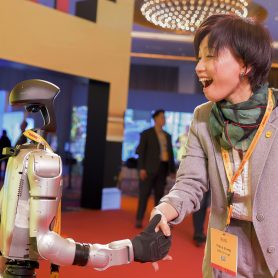 Customer Manager Tracy Liang shakes hand with robot