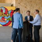 Delegates converse in front of mural