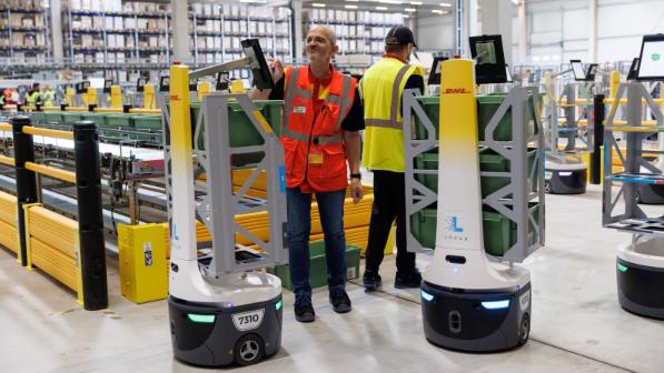 DHL employees in high-vis vests operating LocusBots.