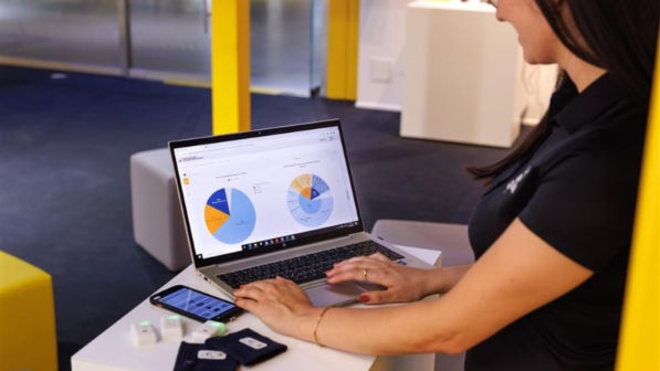 A DHL employee analysing pie charts on a laptop.