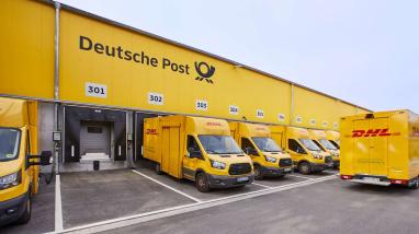 Einige DHL-Lastwagen vor ihren Garagen