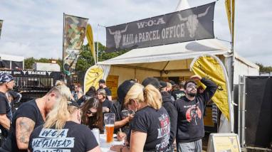 Wackenbesucher schauen sich die Postkarten an