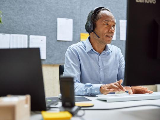 employee-with-headset-works-on-computer