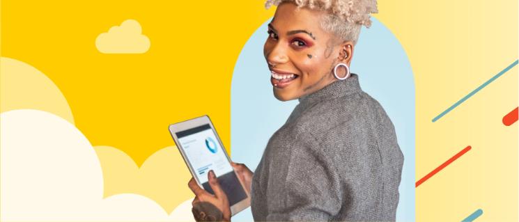 Une femme qui regarde l'objectif et tient une tablette affichant des graphiques.