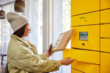Young woman collecting a parcel from a parcel locker