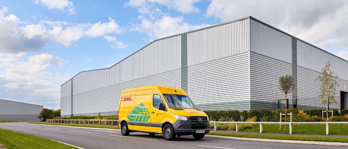 Electric DHL delivery van outside a grey building