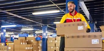A DHL opertaive sorts parcels in a warehouse