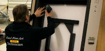 DHL Fine Art technician drilling packing solutions together.