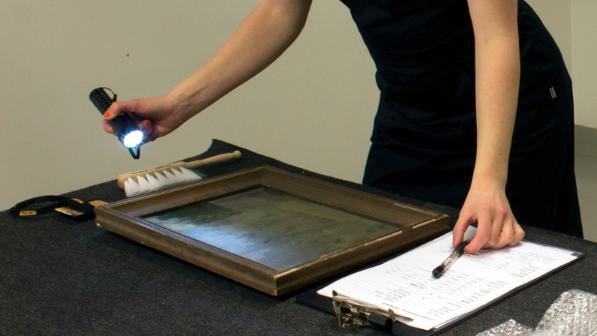 DHL Fine Art conservation staff working on a painting.