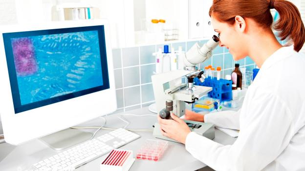 Female lab worker using a microscope