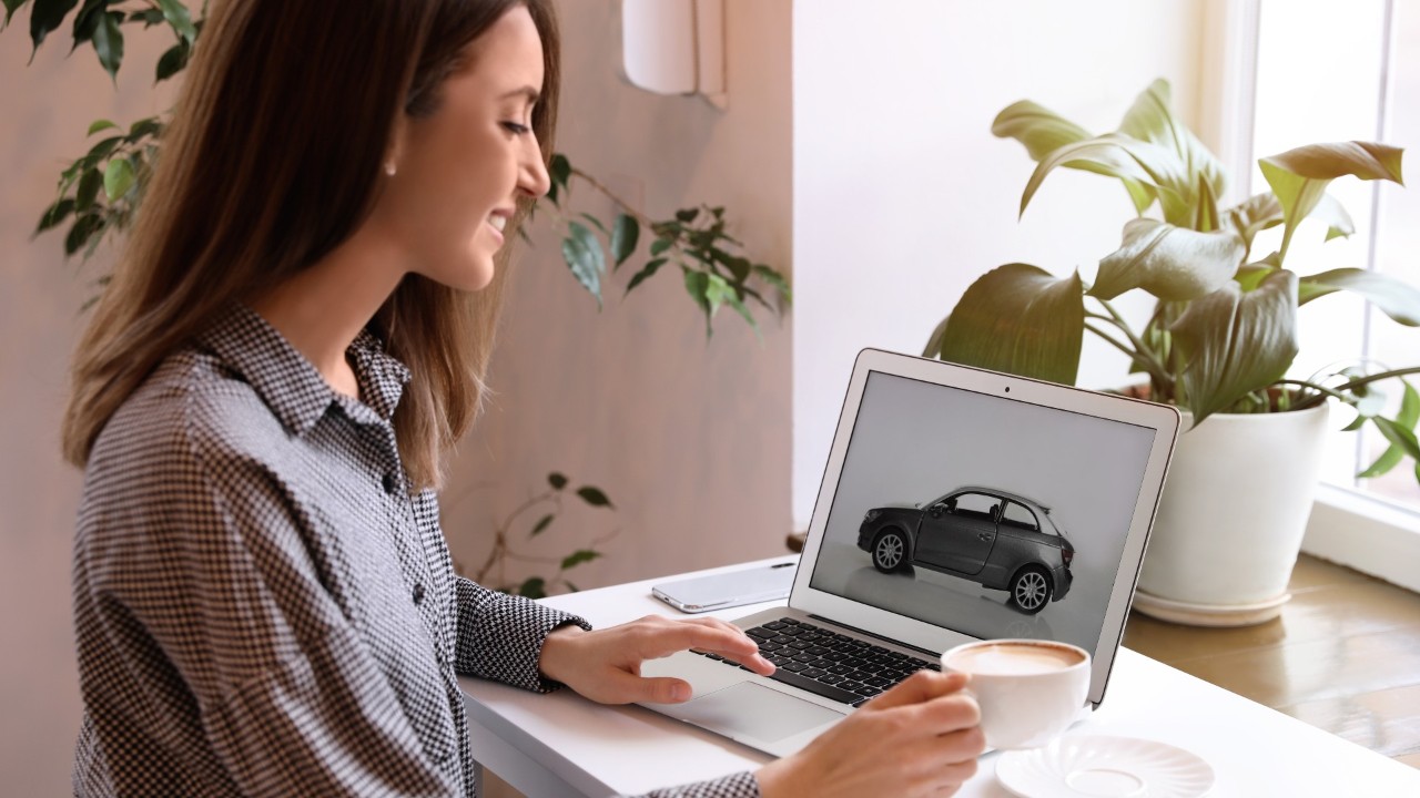 Señora mirando un auto en un computador portátil