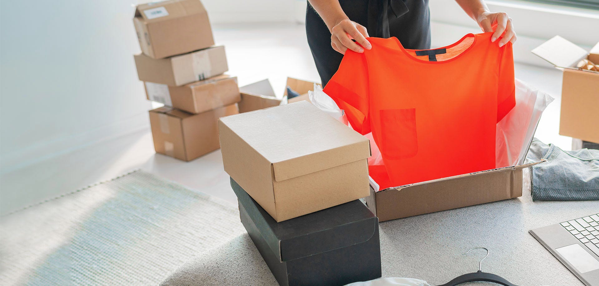 hand folding red t-shirt into box