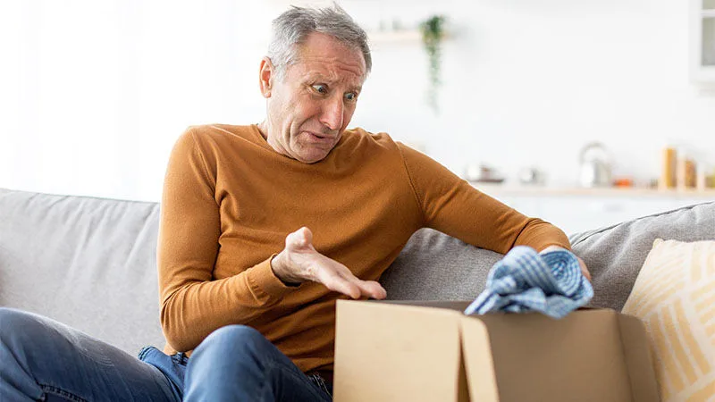man looking at shirt in box