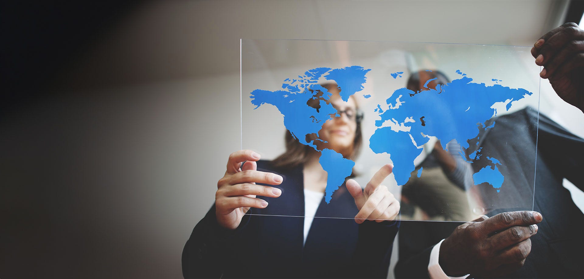 man and woman looking at map of the world