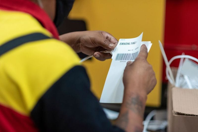 DHL Express employee applies a label to the parcel, ensuring the safe and compliant sending of medicine abroad.