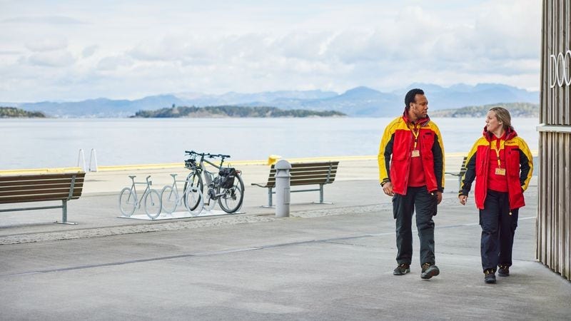 DHL Express employees walking by a lake.