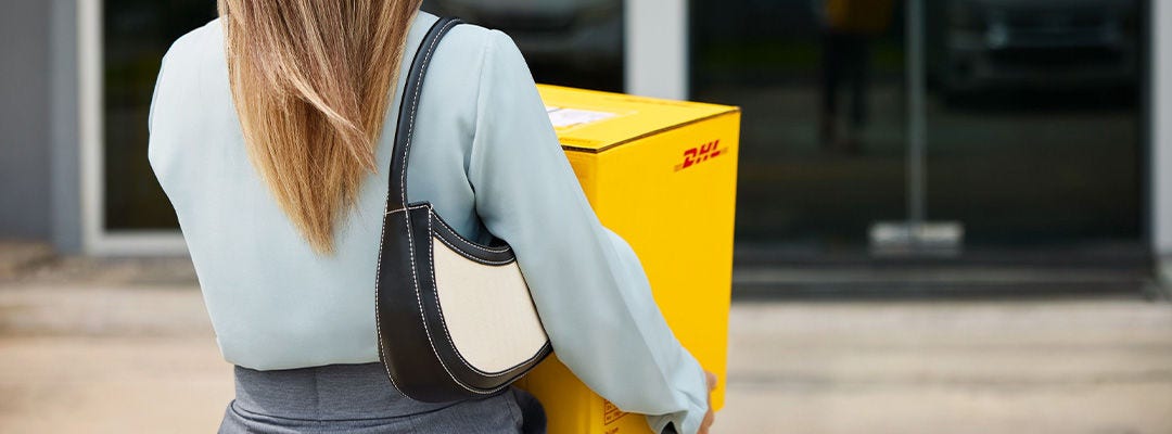 Woman holding a yellow DHL box