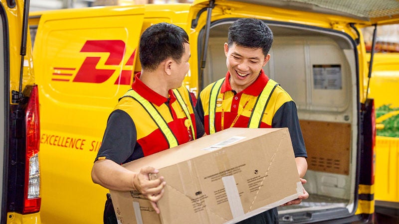 שני שליחים של DHL מחזיקים קופסה חומה