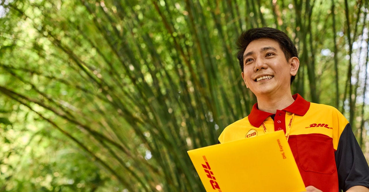 DHL Express employee holding an envelope containing key shipping documentation for customs clearance