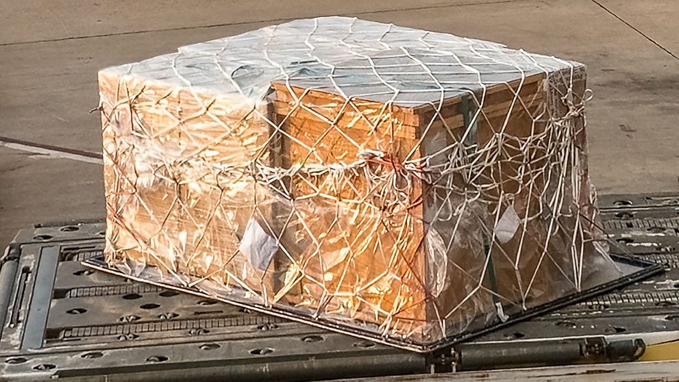 Cargo, containers and pallets are unloaded from a commercial aircraft at Washington airport using container loaders