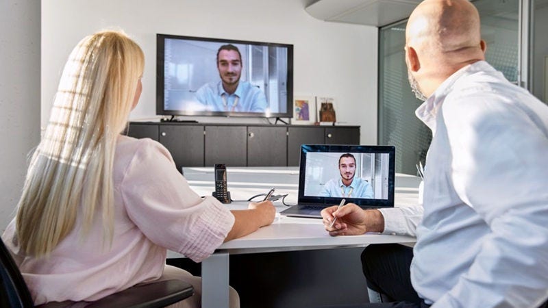 Employees in front of a laptop in a zoom meeting with a DHL expert.
