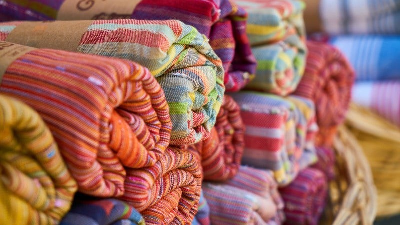 Colorful fabrics rolled and stacked.