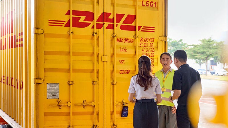 DHL truck with people standing in front of it having a discussion