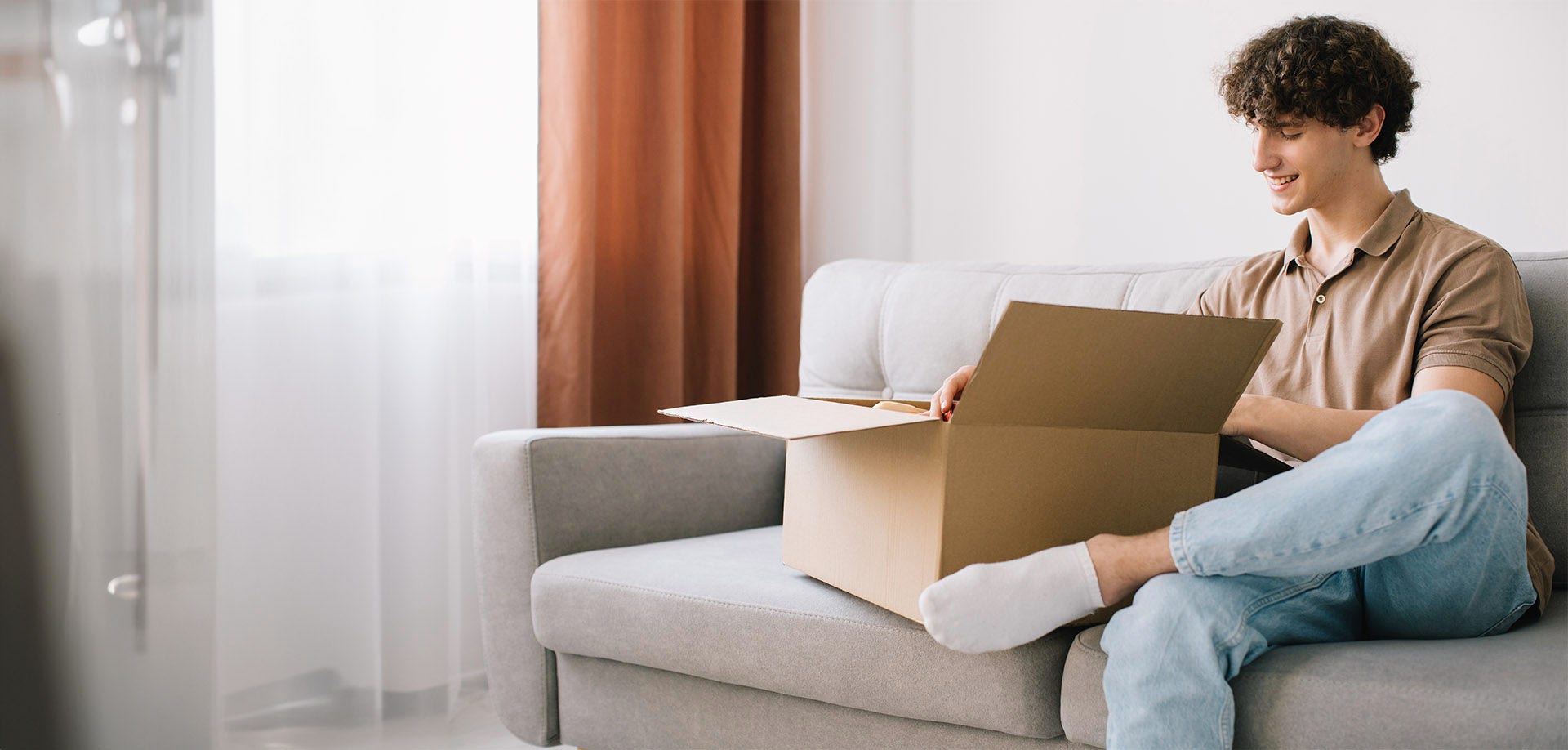 man smiling at brown box