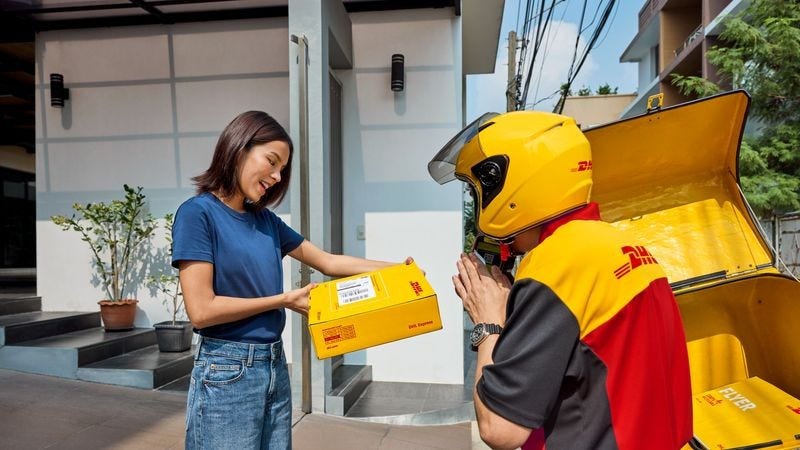 A DHL employee delivers a package to a customer. 