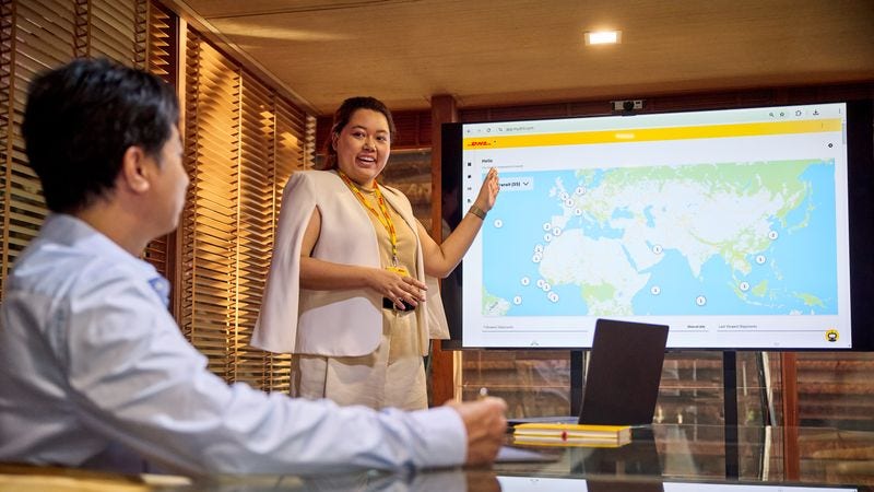 female dhl express employee showing a business owner the mydhl+ page 