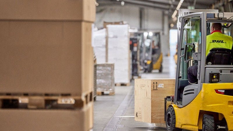 dhl employee operating forklift for pallet cargo