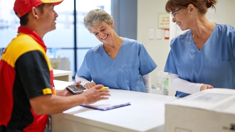 dhl delivery man delivering medical supplies at a medical centre