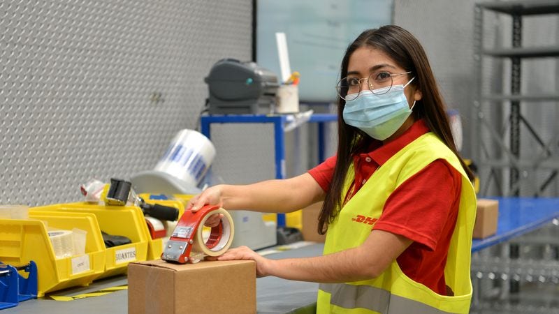 dhl express employee taping parcel