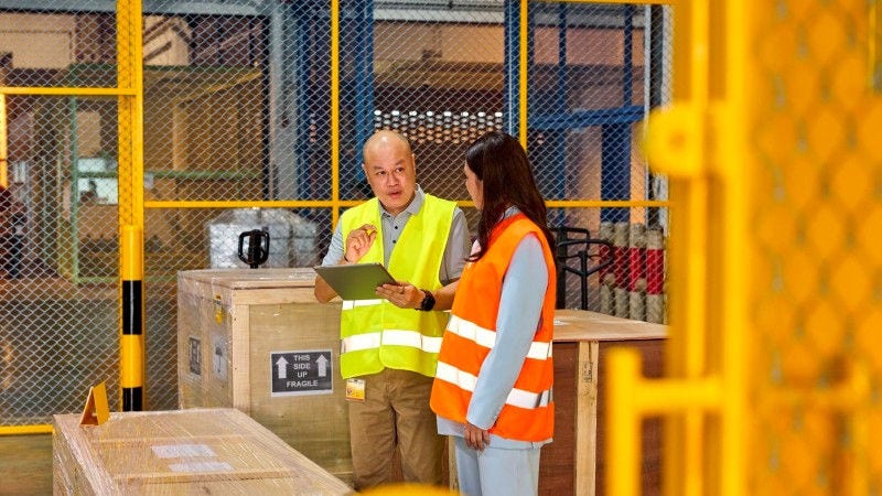 A male DHL expert overseeing the transport of mining equipment.