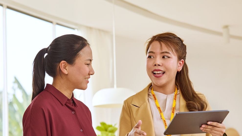 Seorang karyawan DHL menjelaskan peraturan ekspor barang elektronik kepada pemilik bisnis