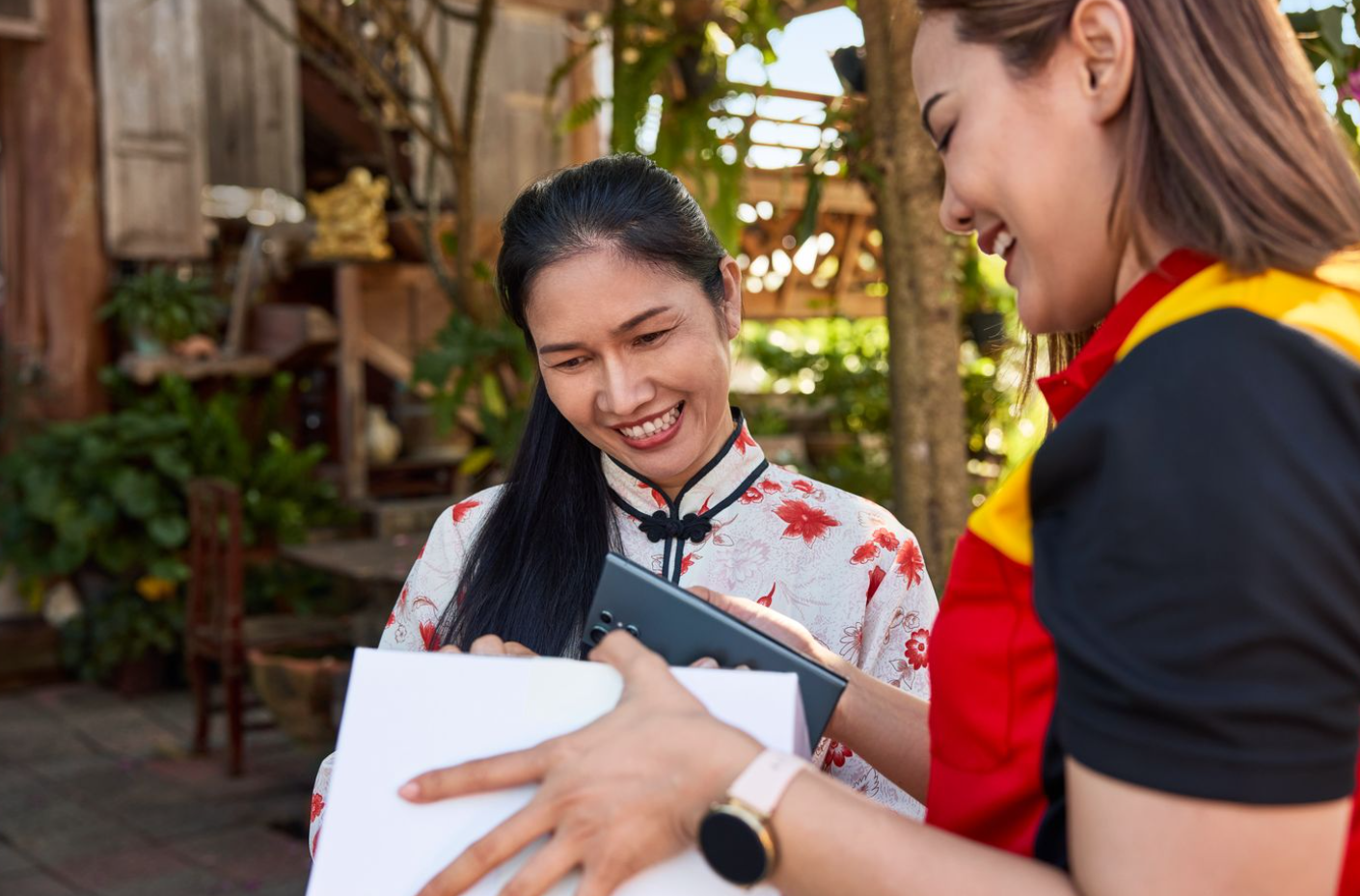 customer in festive attire receiving a delivery from a dhl express employee