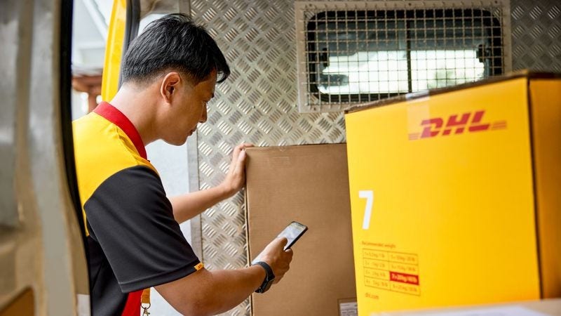 DHL delivery staff scanning parcel label for overseas shipping documentation