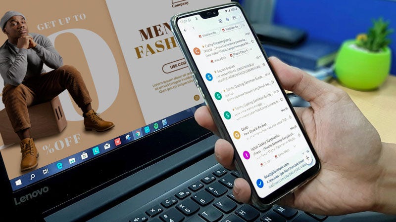 Une personne regardant un e-mail sur un téléphone devant un ordinateur portable affichant un site web