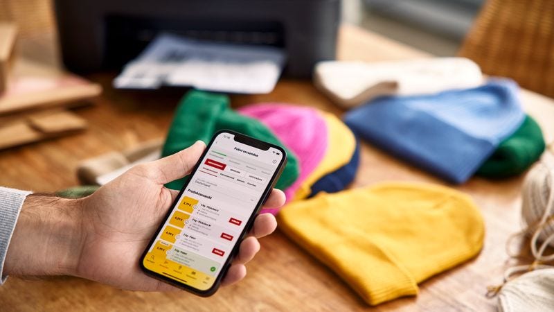 picture of a someone using a phone to arrange a parcel pickup