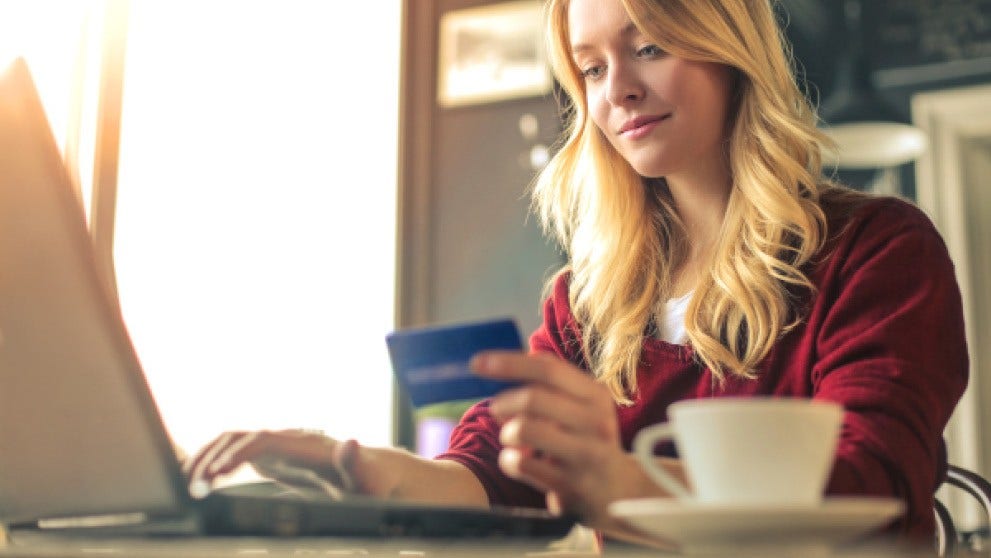 Consumidora pagando uma compra online com cartão, momento em que o IVA é cobrado pelo IOSS