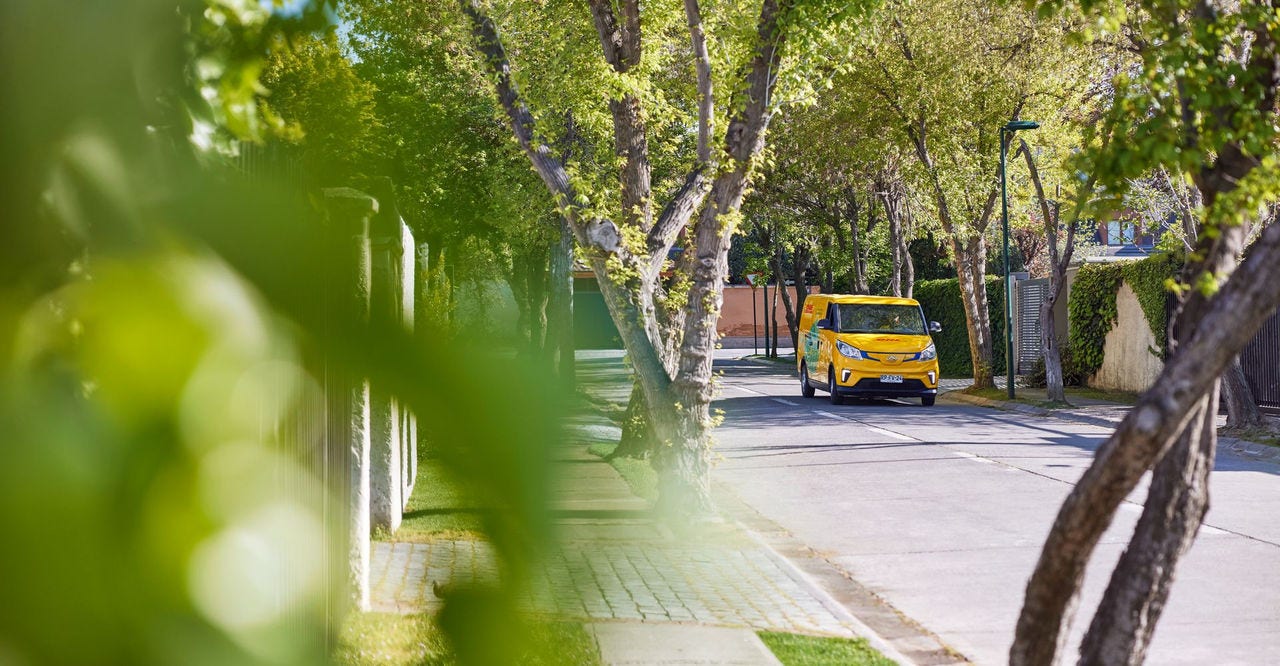 An electric DHL van driving on the road