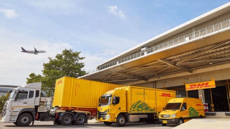 Inline Static ( 800x450)  - A DHL truck with trailer, an electric DHL truck and an electric DHL van parking at the operation area