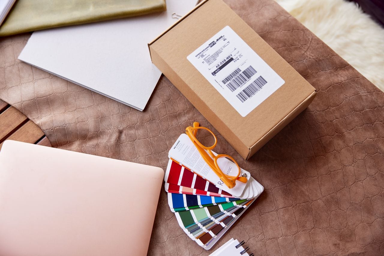 A brown parcel is laying on the table in a work space located in a rustic cottage. 