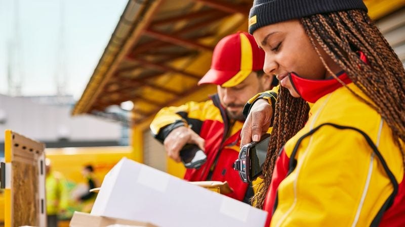 Two DHL employees scanning parcels.