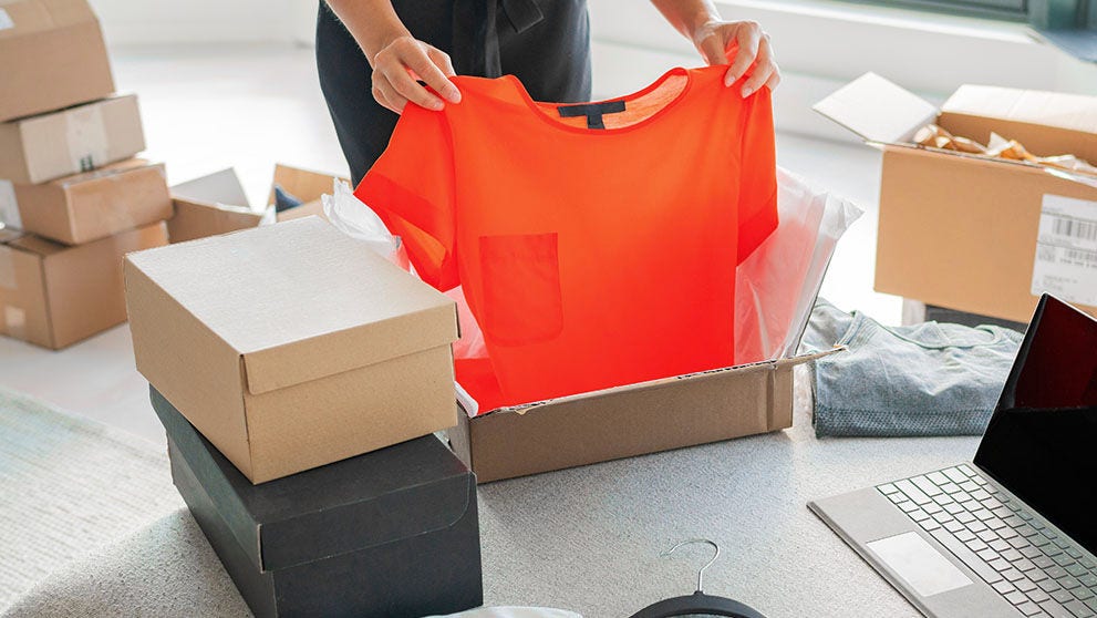 hand folding red t-shirt into box