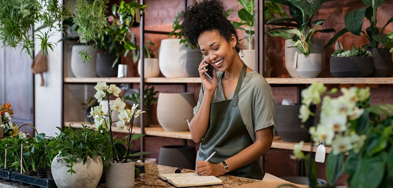 woman smiling and writing in a notebook
